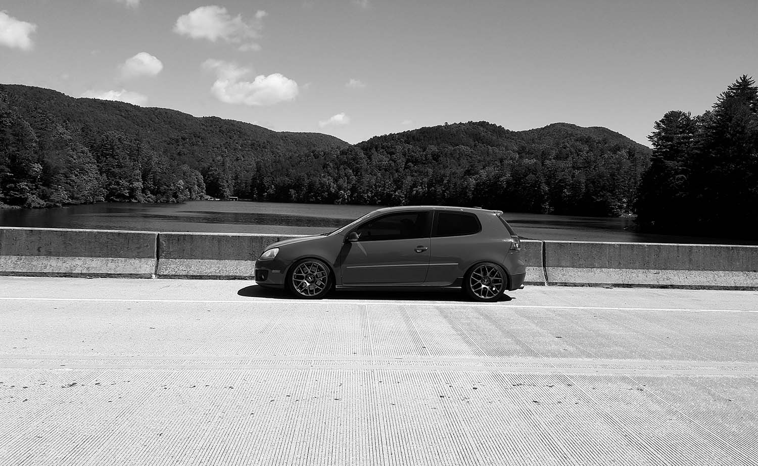 A vehicle, presumably a VW or Audi, broken down on the side of a road, illustrating the need for specialized repair services.